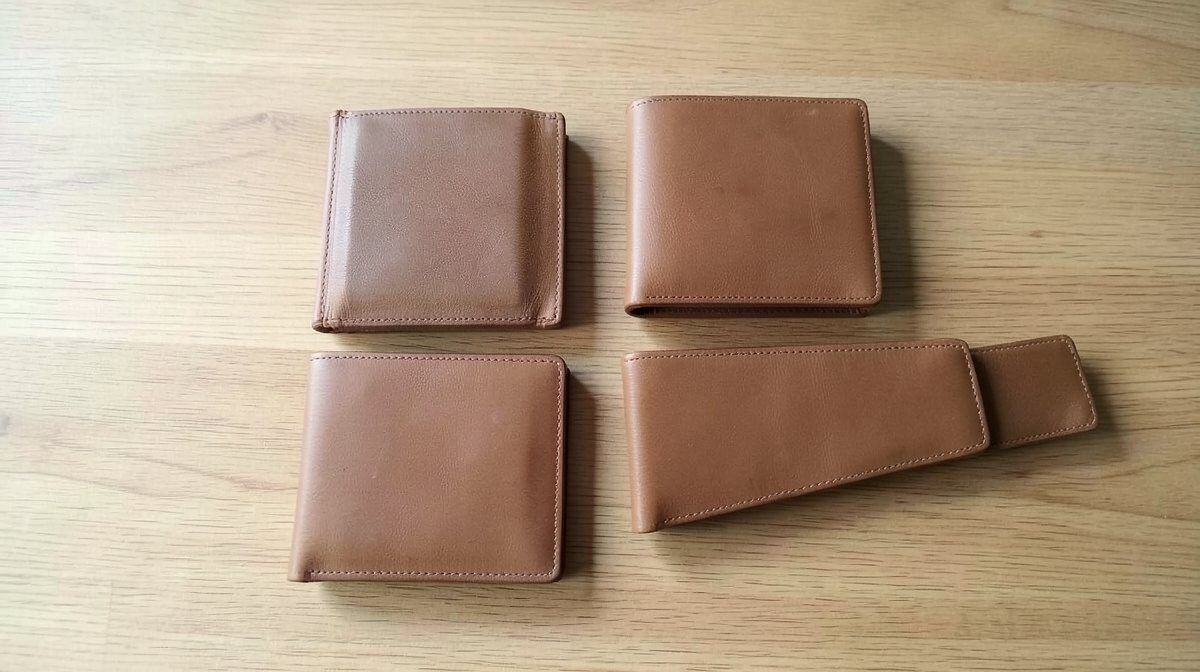Quel portefeuille choisir : les neuf formats et la poche de chacun 1 Quel portefeuille choisir : quatre portefeuilles en cuir cognac posés sur une table en bois